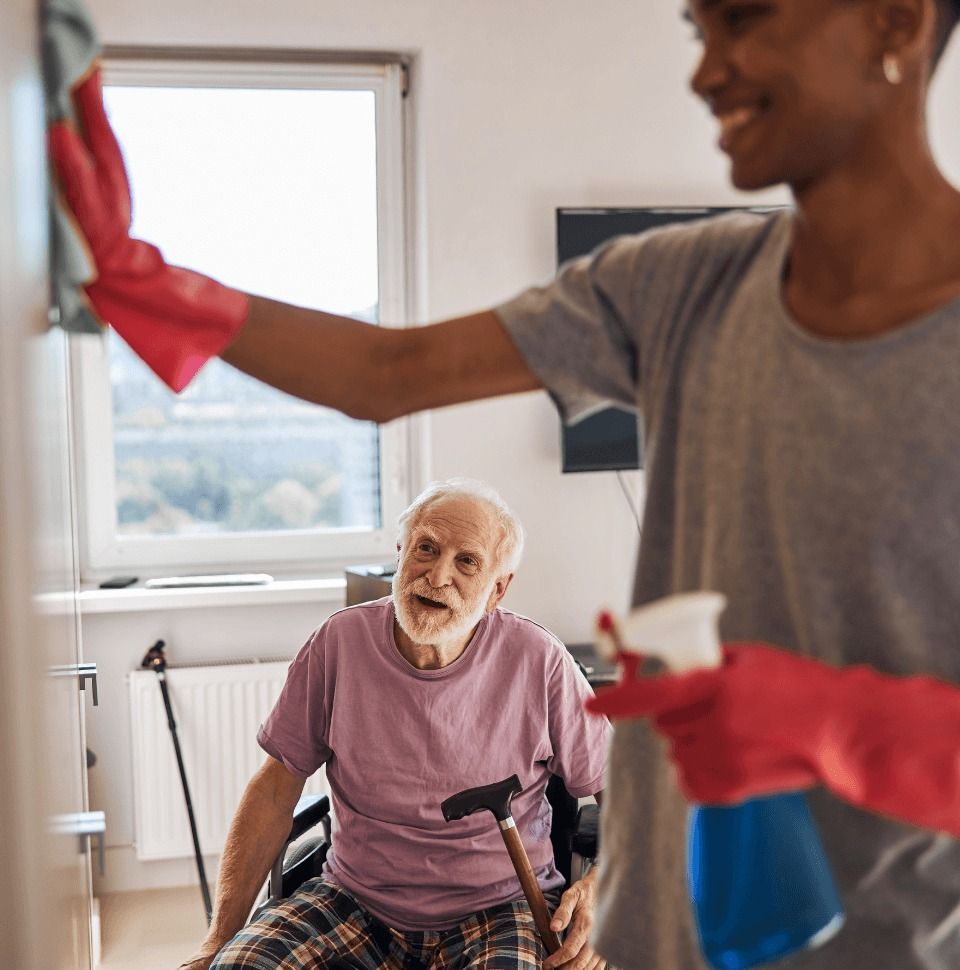 An Elderly Man in A Wheelchair Is Being Helped by A Younger Man — Coast 2 Coast Disability Support Services in Taree, NSW