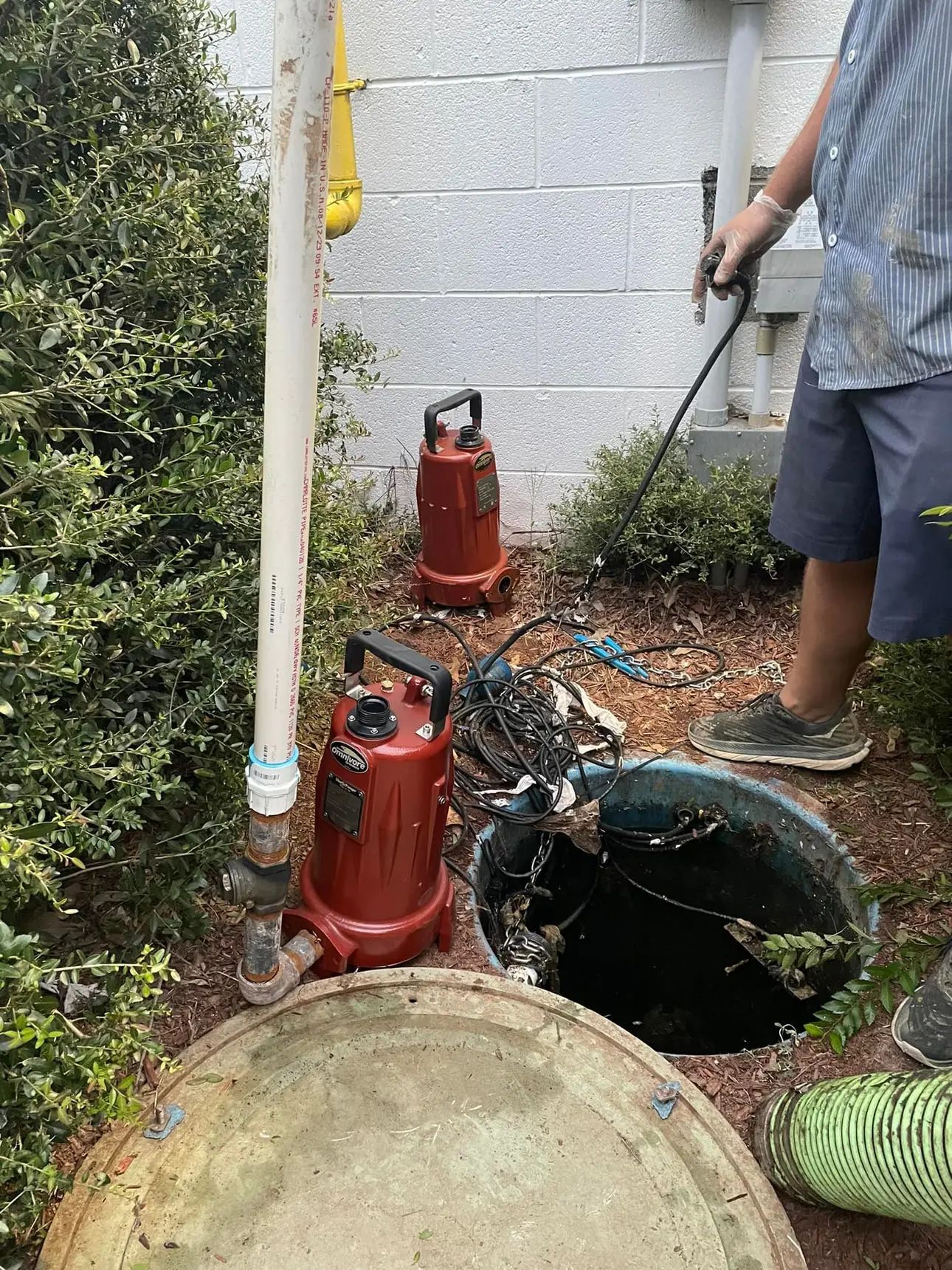 A man is cleaning a septic tank with a hose.