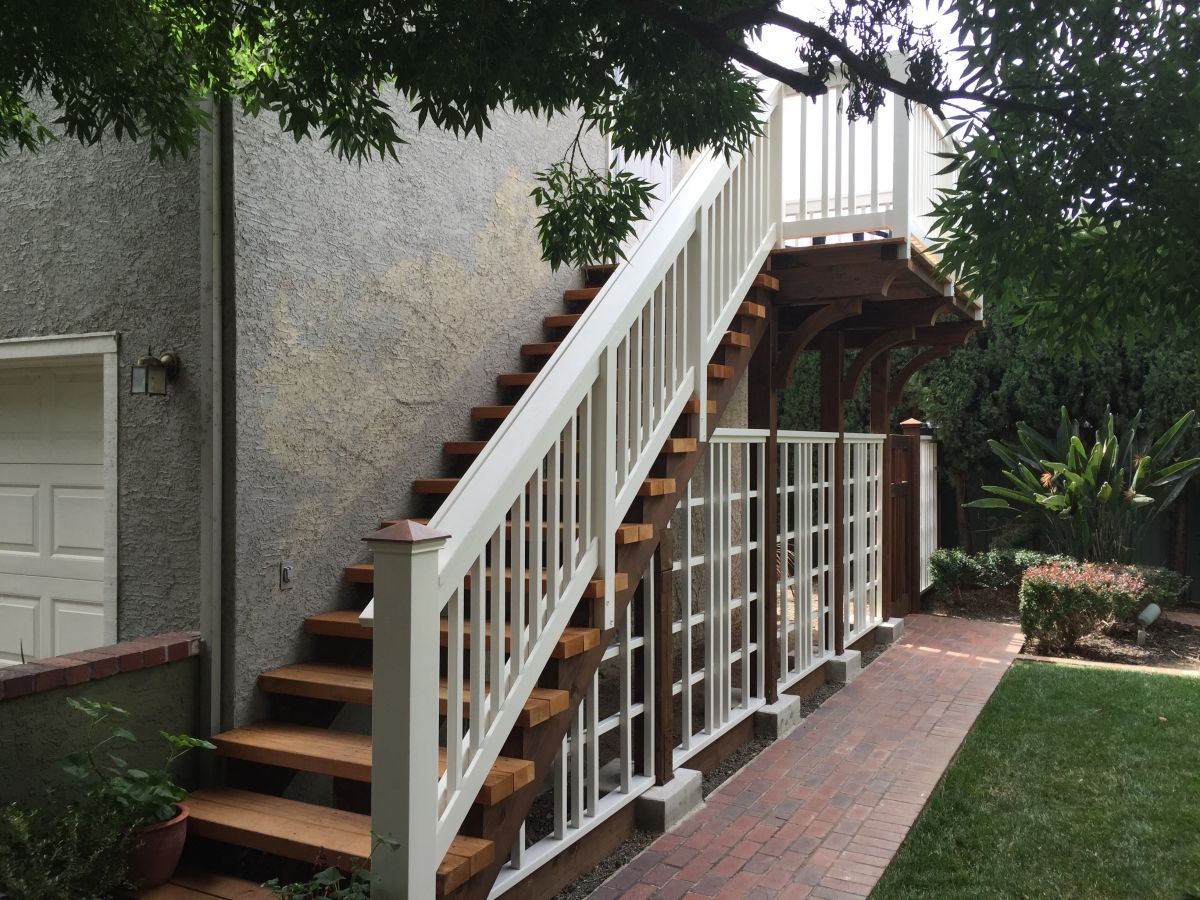 Wood stairs leading to wood deck with white railing