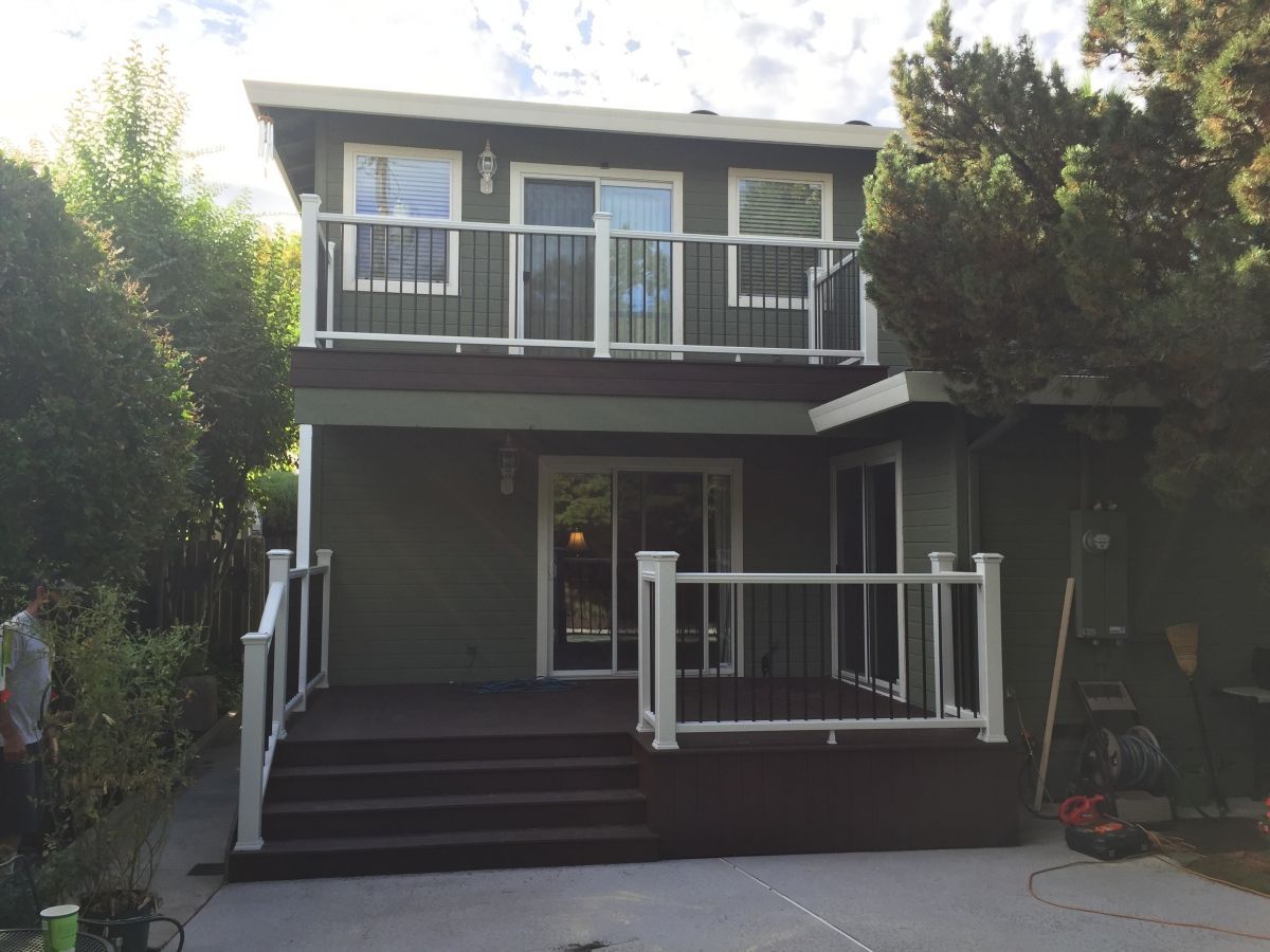 newly installed dark colored deck with white railing and black posts
