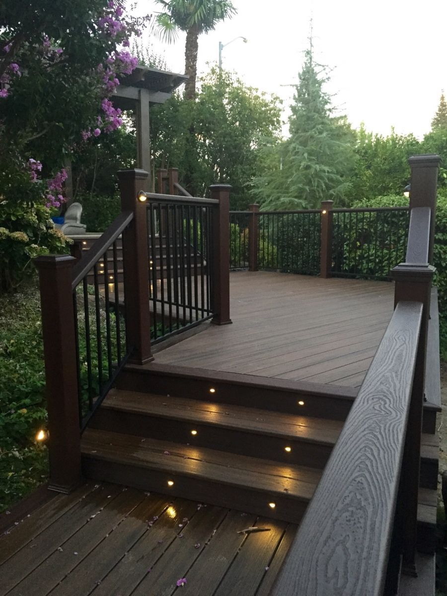 newly installed backyard wood deck with integrated lighting throughout the structure