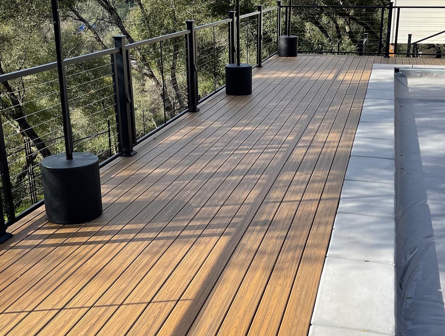 black metal railing and black metal posts surrounding decking