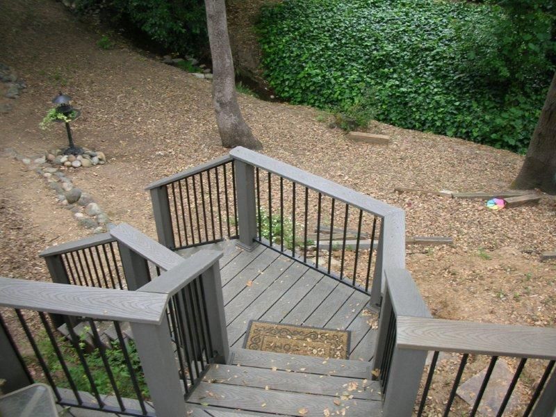 gray stained wood deck railing with wrought iron decoration