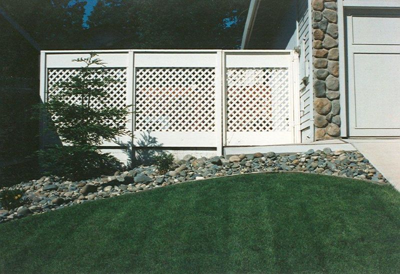 white fence with white lattice in the middle of the fence