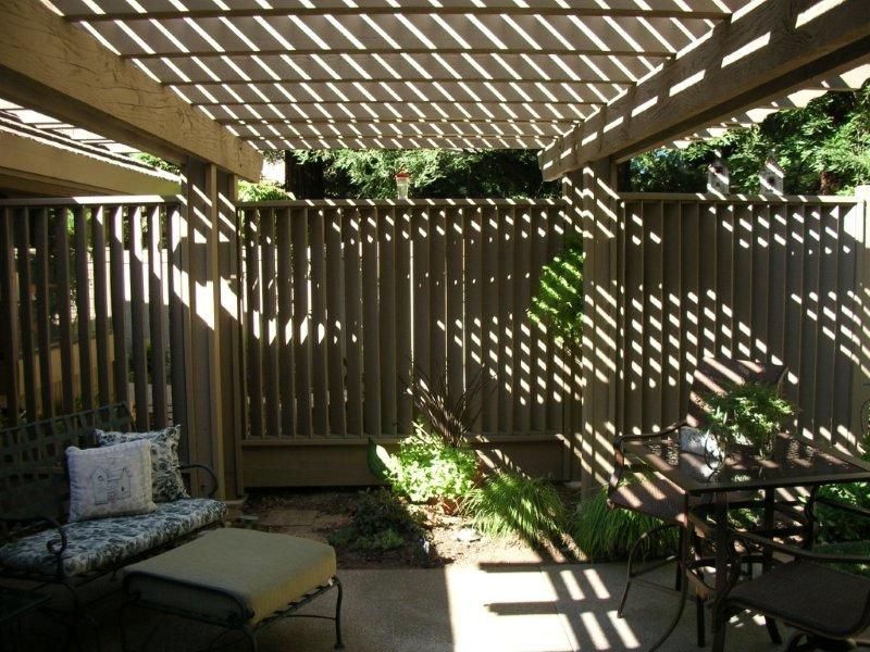 wood pergola providing shade to back patio area