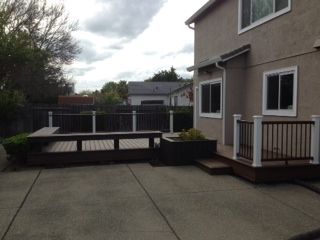 newly installed backyard wood deck with bench seating with step and railings