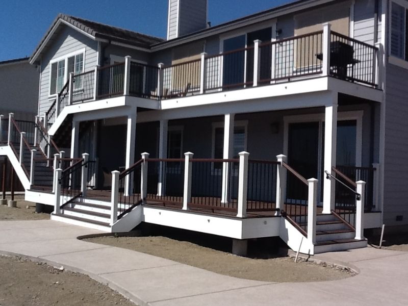 two level deck system with new dark wood railings and white posts