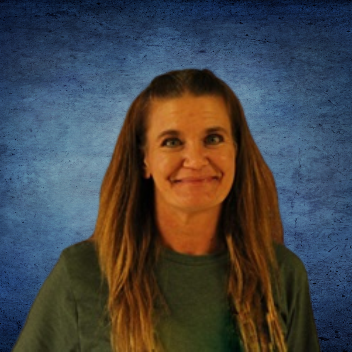 A woman in a green shirt is smiling in front of a blue background.
