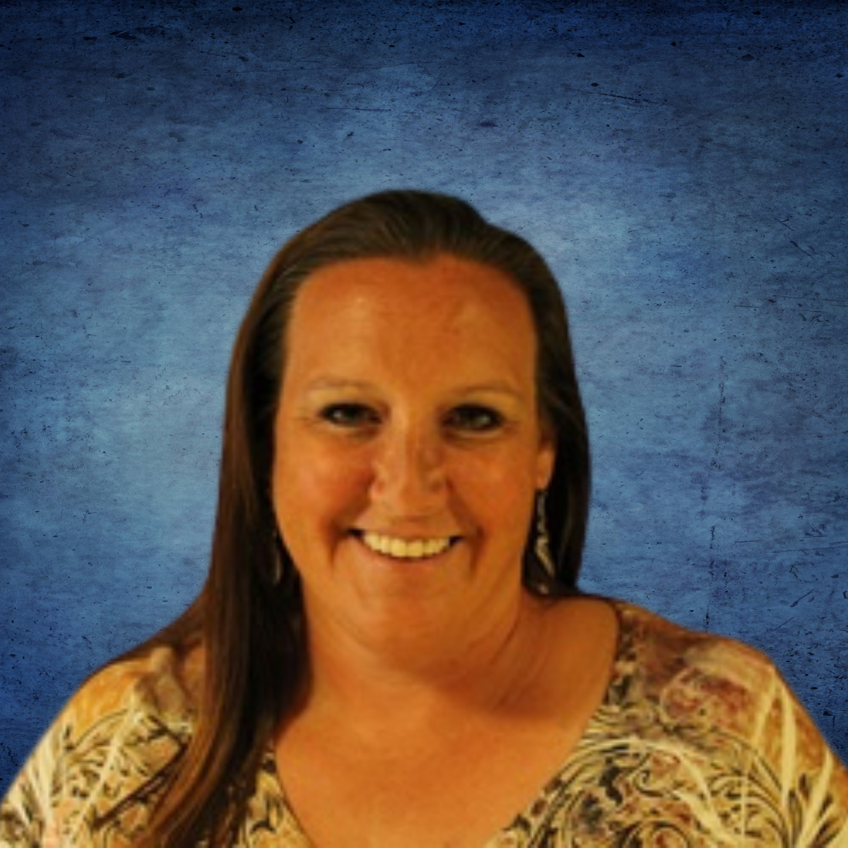 A woman with long hair is smiling in front of a blue background