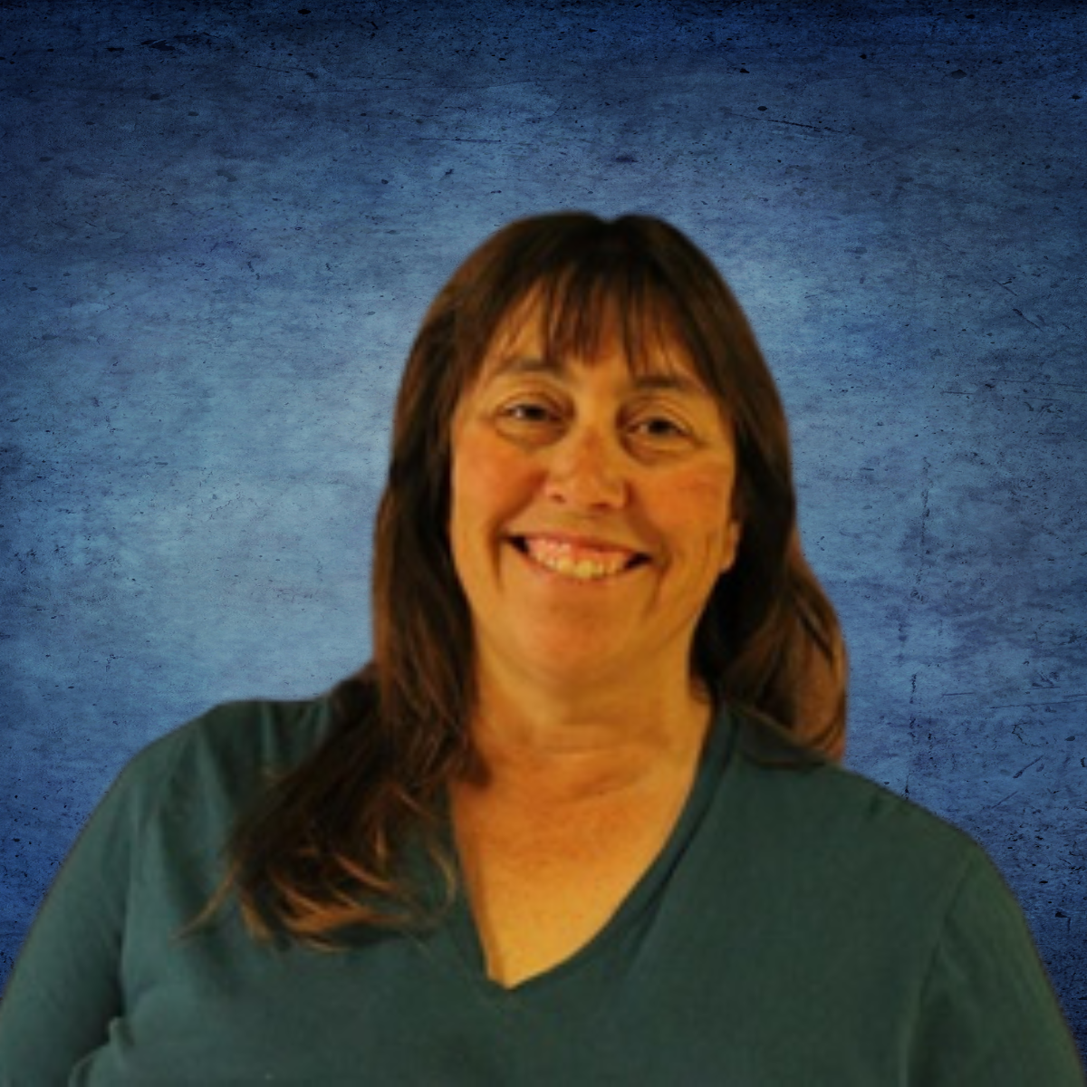 A woman in a green shirt is smiling in front of a blue background