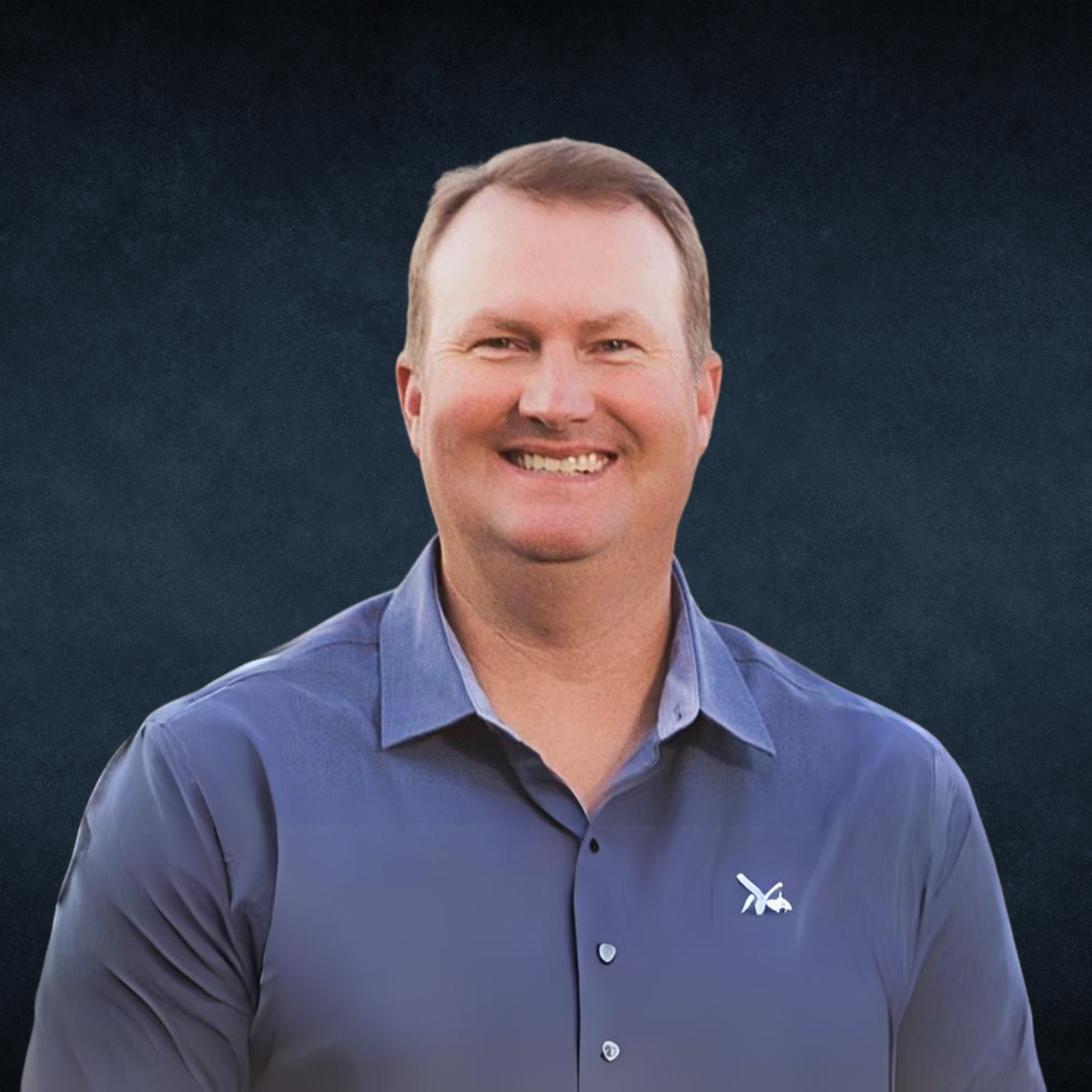 A man wearing a blue shirt with a white x on it