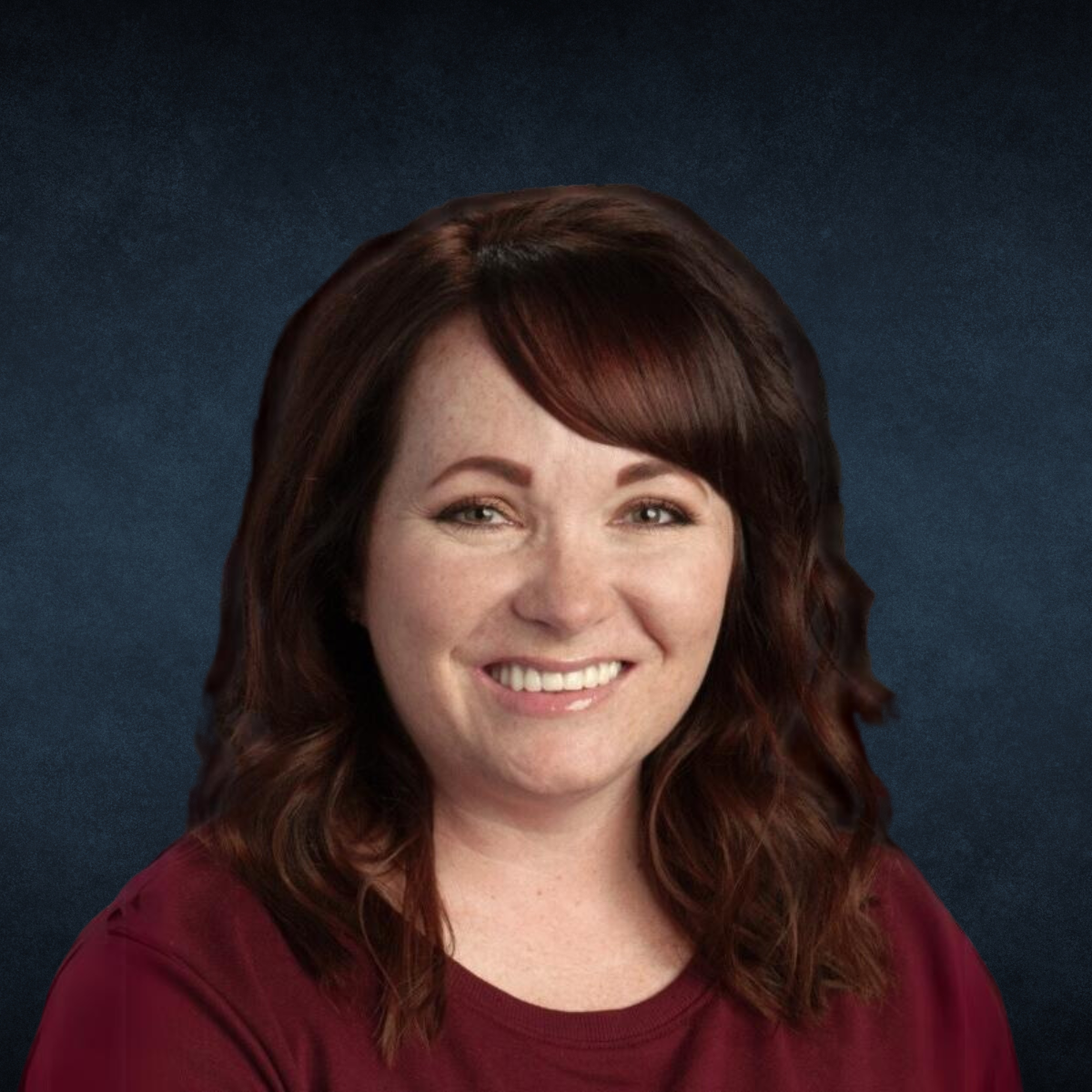 A woman in a red shirt is smiling for the camera