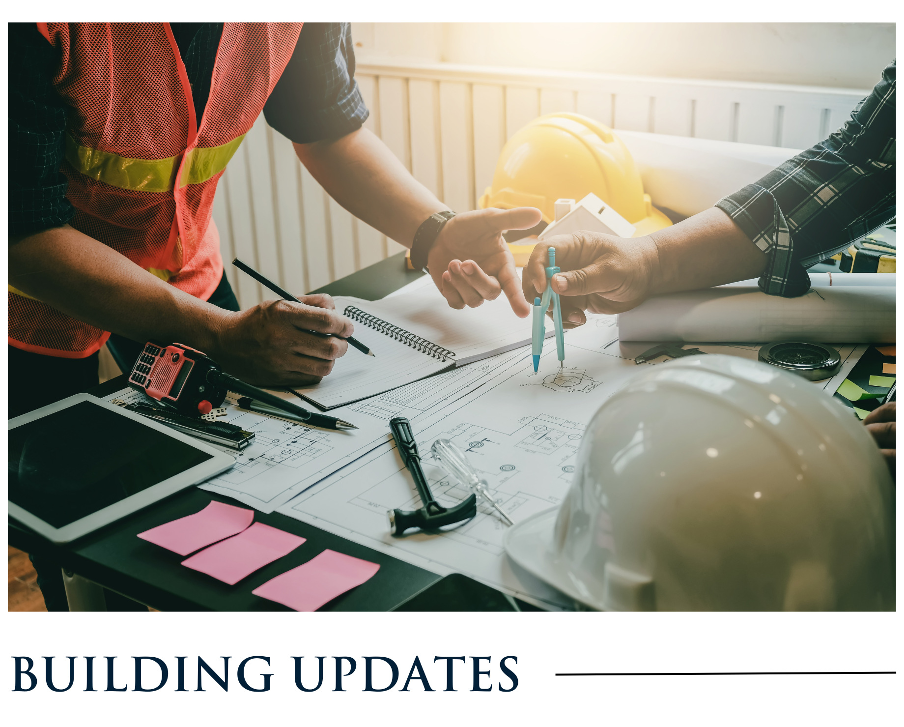 A group of construction workers are sitting at a table looking at a blueprint.
