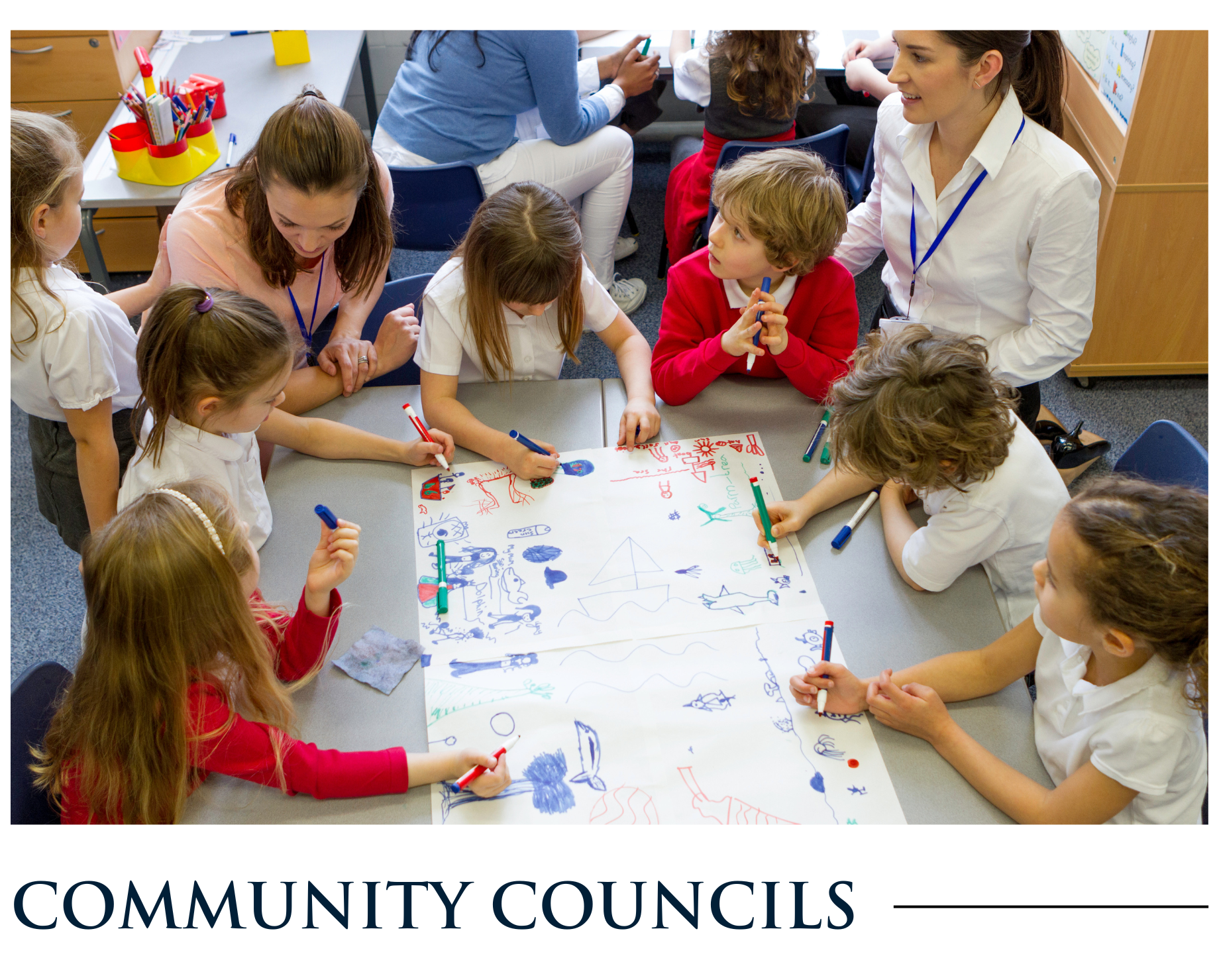 A group of children are sitting around a table drawing on a piece of paper.