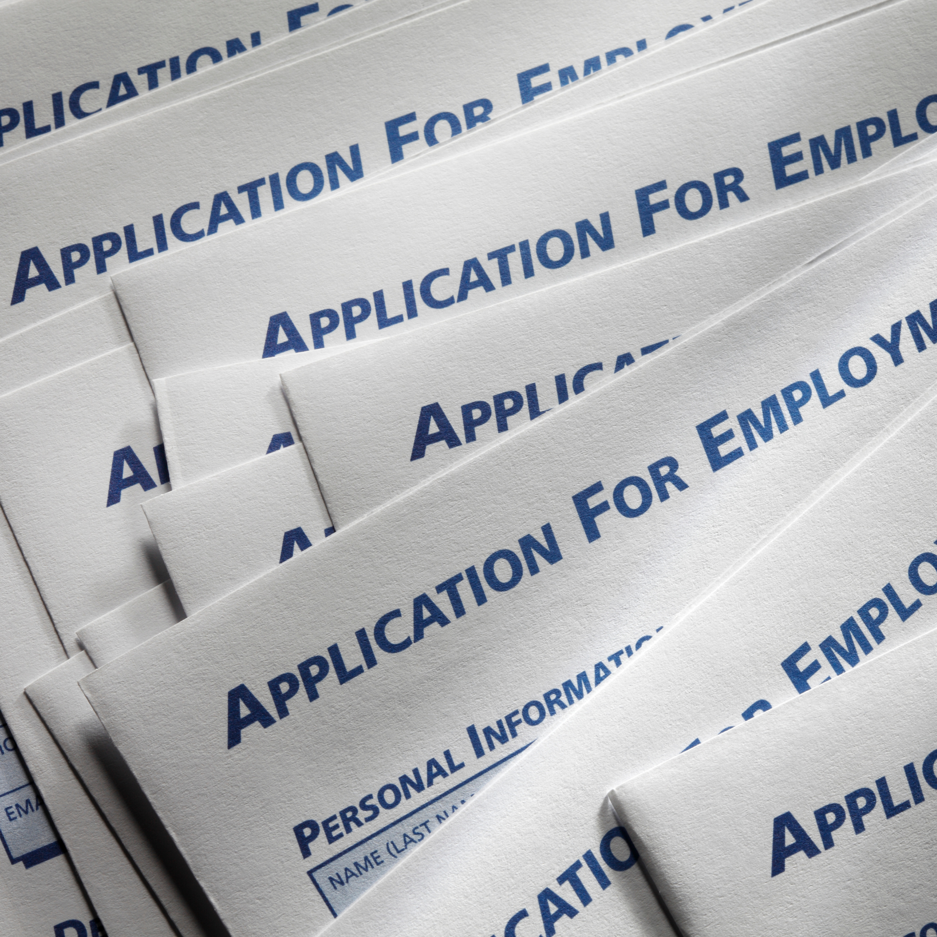 A bunch of applications for employment are stacked on top of each other