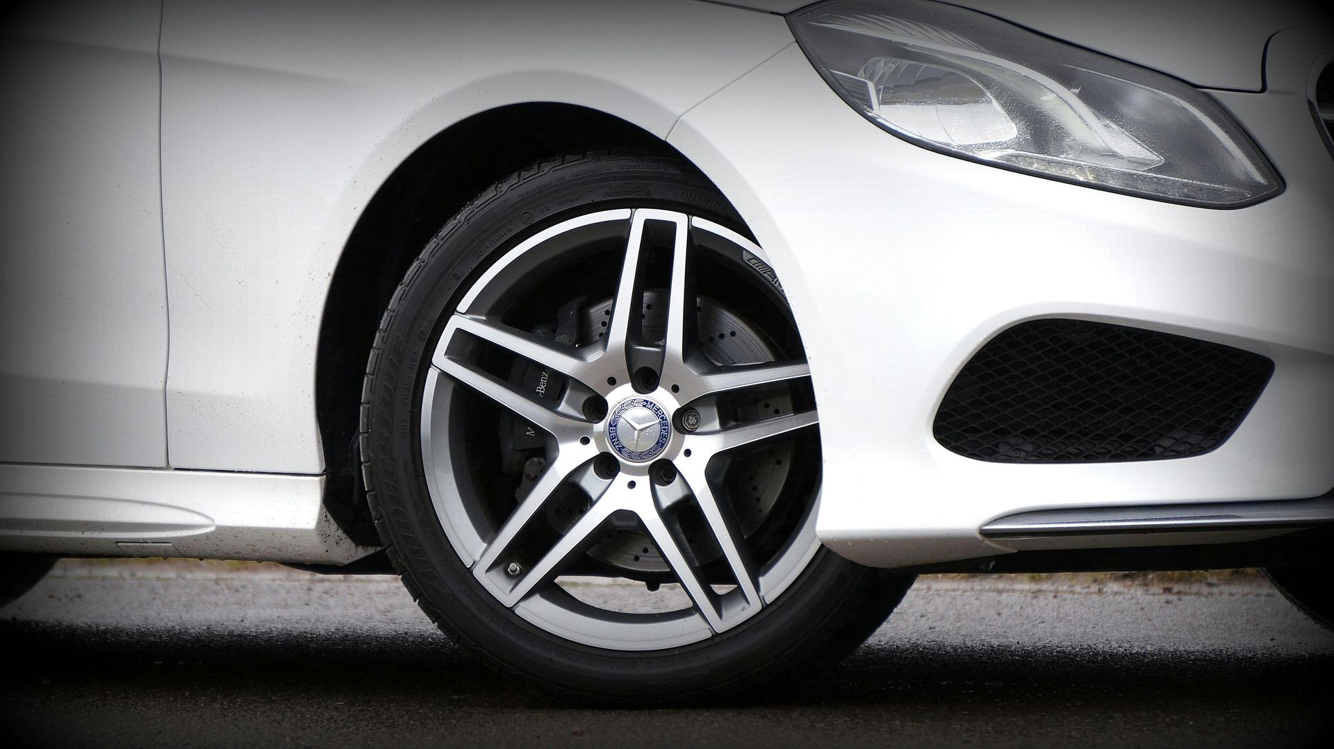 A close up of a white car with a black rim