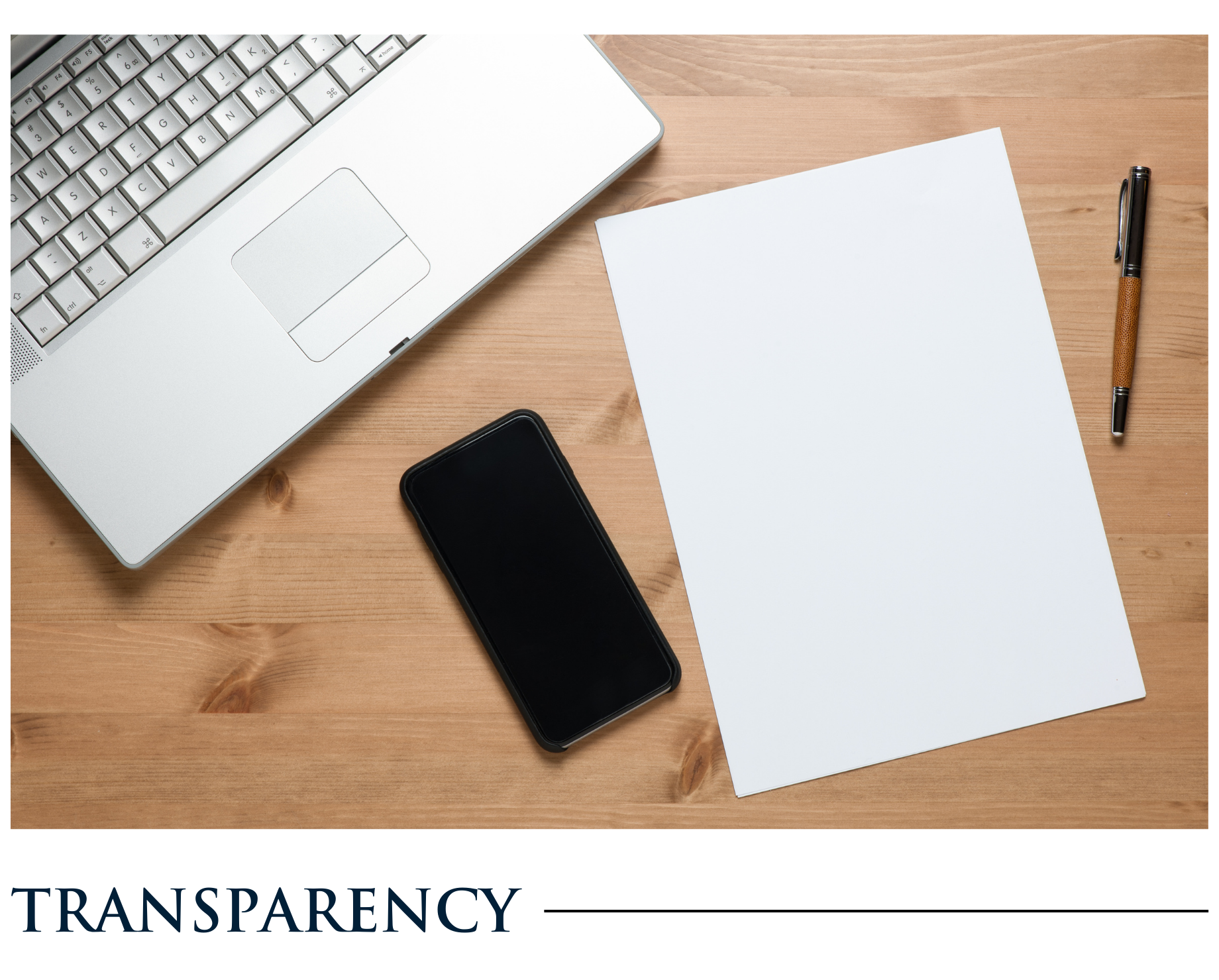 A laptop , cell phone , pen , and piece of paper on a wooden table.