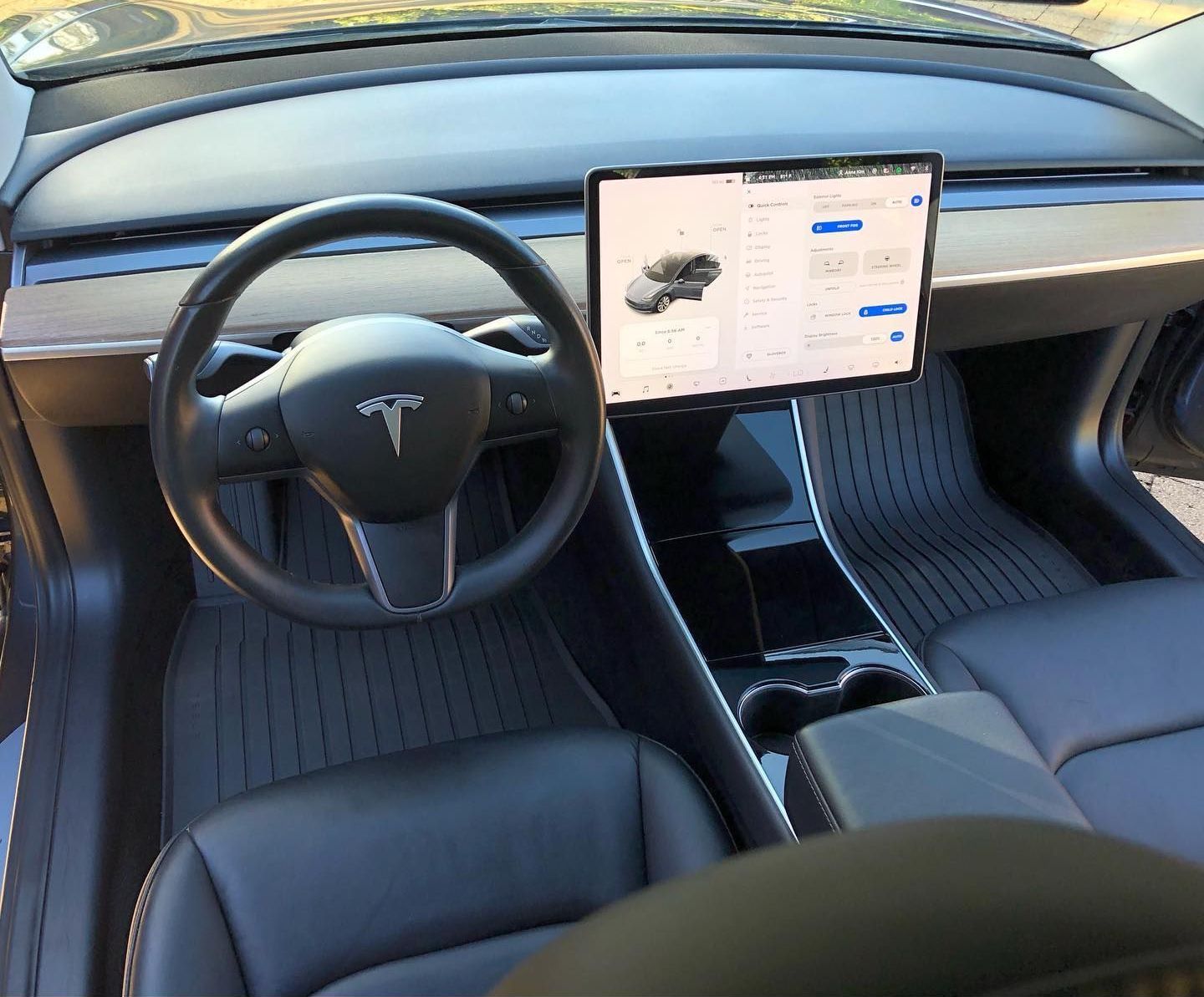 the interior of a tesla model 3 with a tablet on the dashboard
