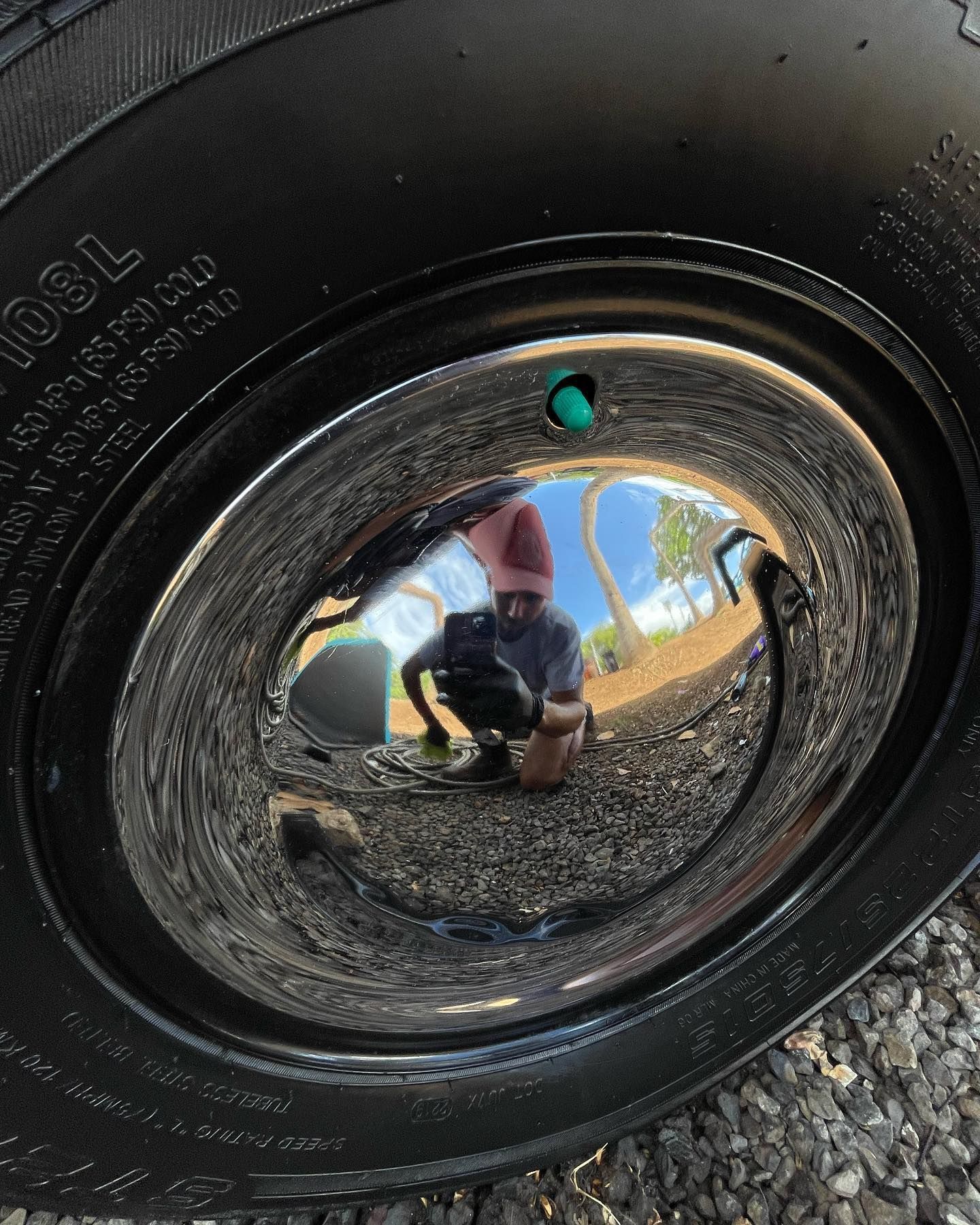 a close up of a tire with a reflection of a person in it