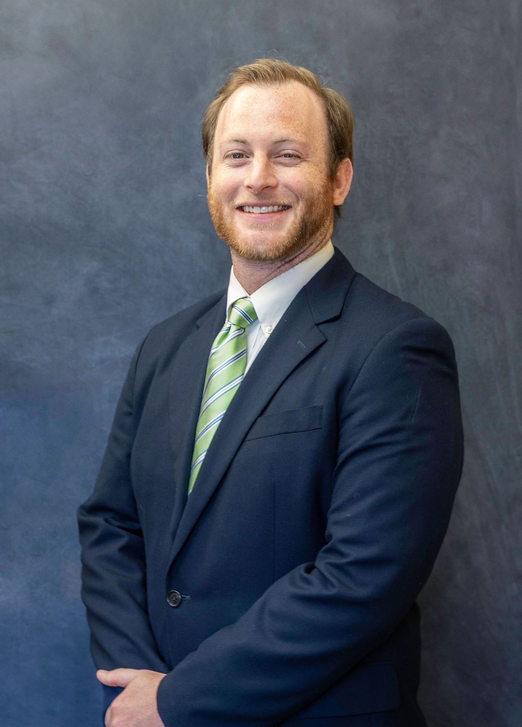 A man in a suit and tie is smiling for the camera.