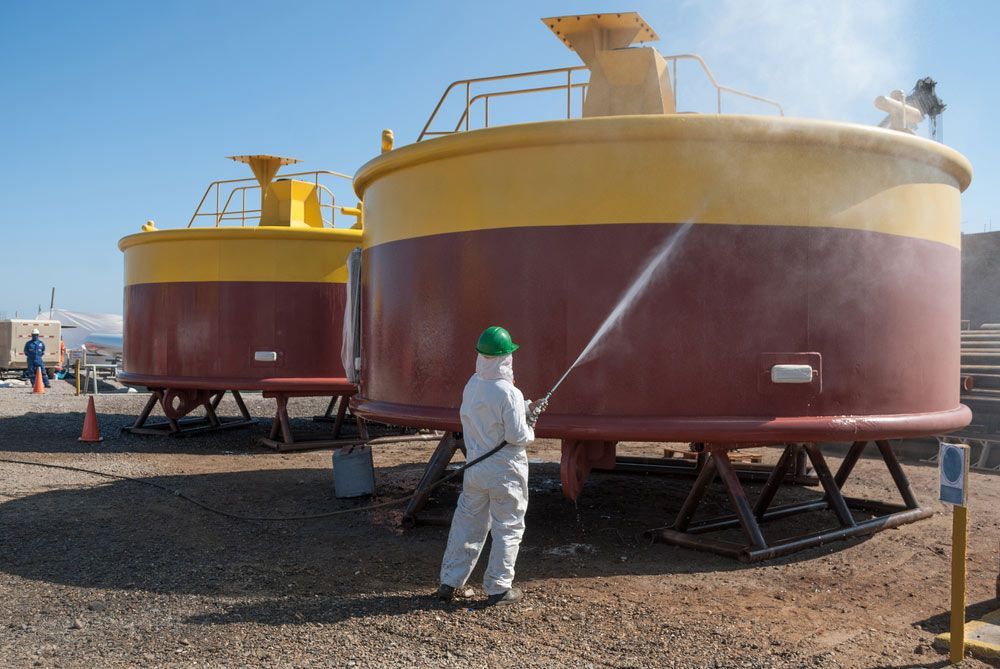 Uniformed Workers Performing Sandblasting Process — Procoat QLD in Ryan, QLD
