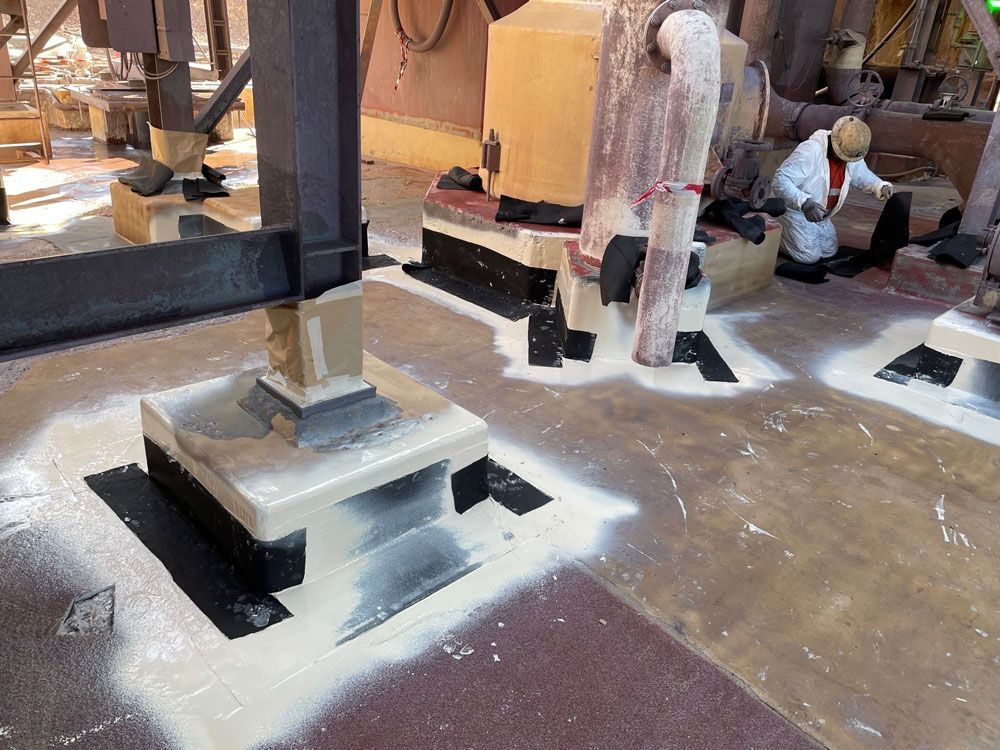A Man Is Painting A Concrete Structure In A Factory — Procoat QLD in Ryan, QLD