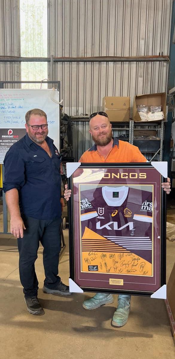 Two Men Are Standing Next To Each Other Holding A Framed Picture Of A Hockey Jersey — Procoat QLD in Ryan, QLD