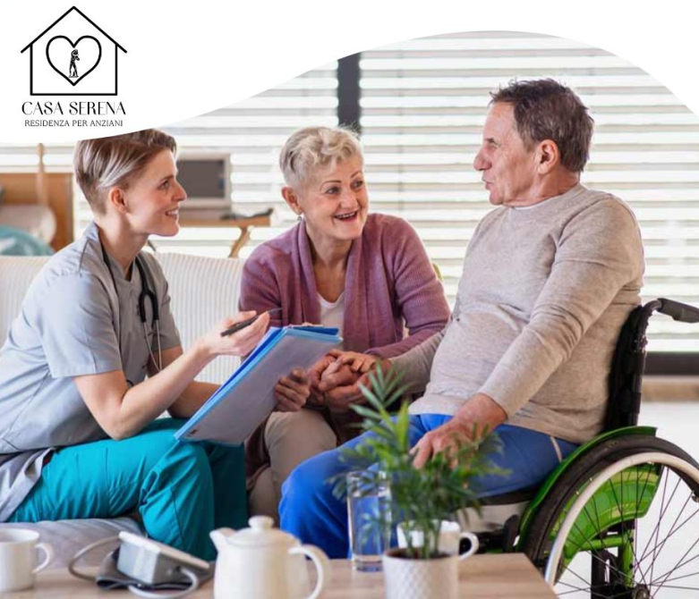 Un'assistente sociale assiste una coppia di anziani a casa; uno di loro è su una sedia a rotelle.