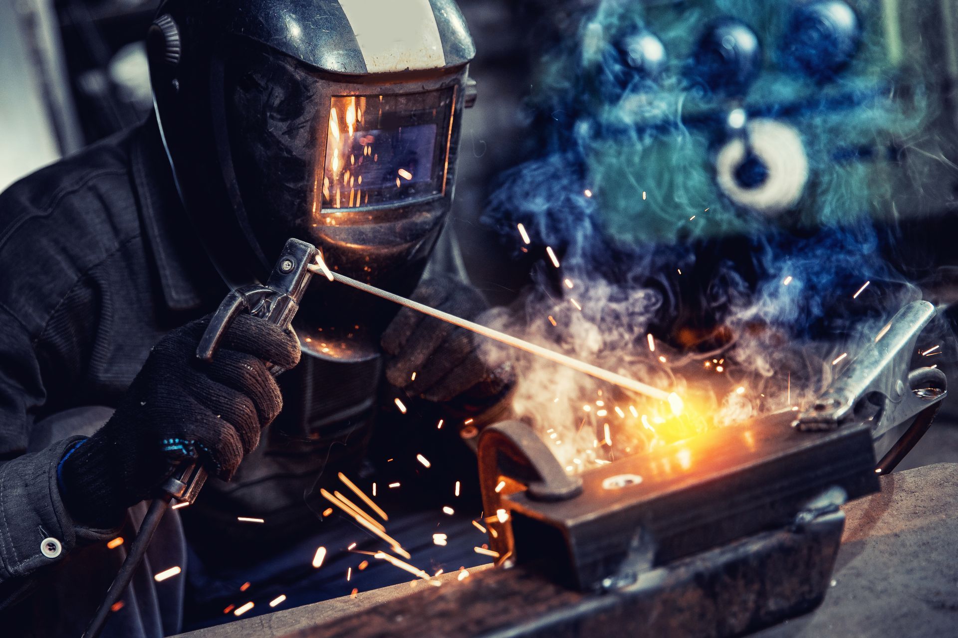 Welder in a workshop, welding metal