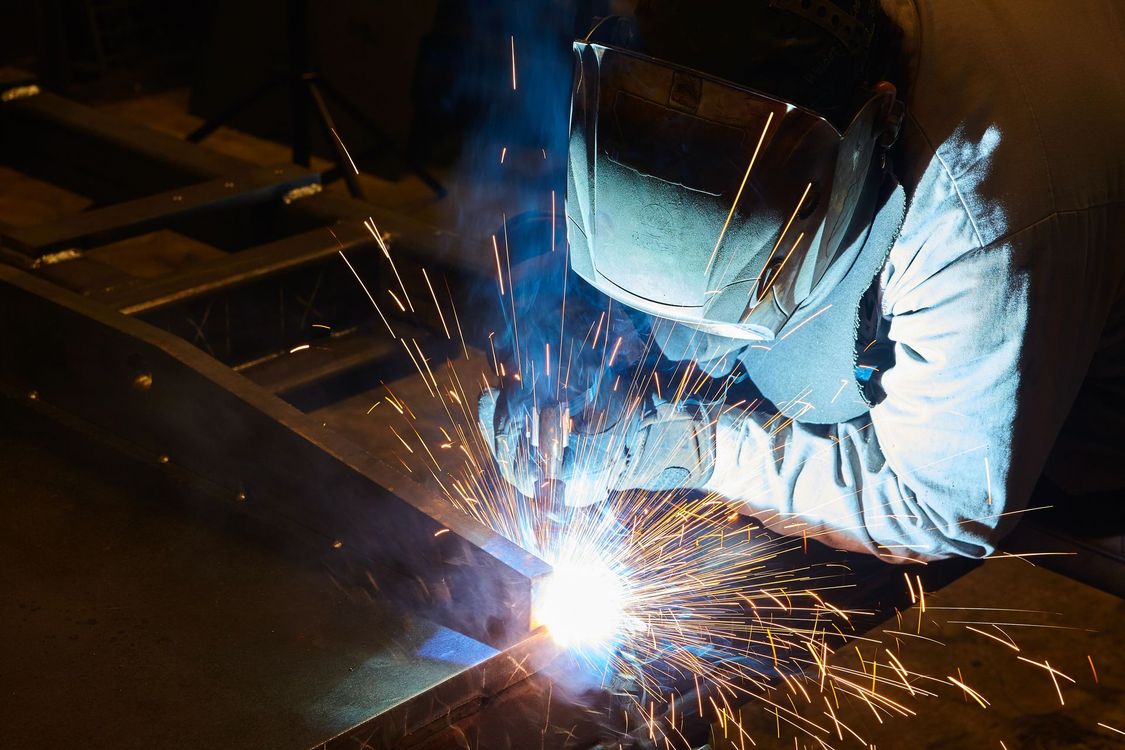 Welder in protective gear welding metal Welder in protective gear welding metal