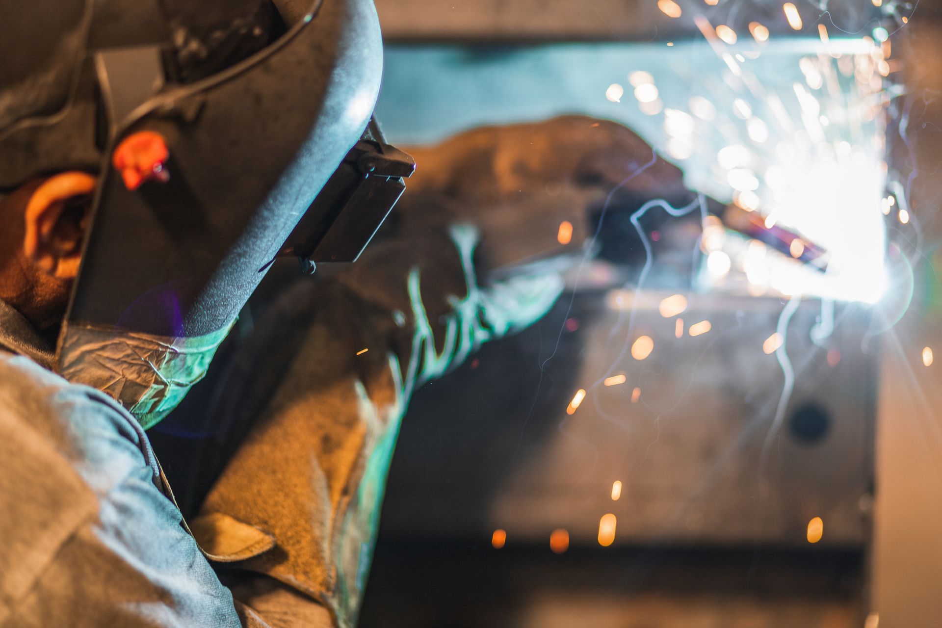 Welder wearing a protective mask welding metal