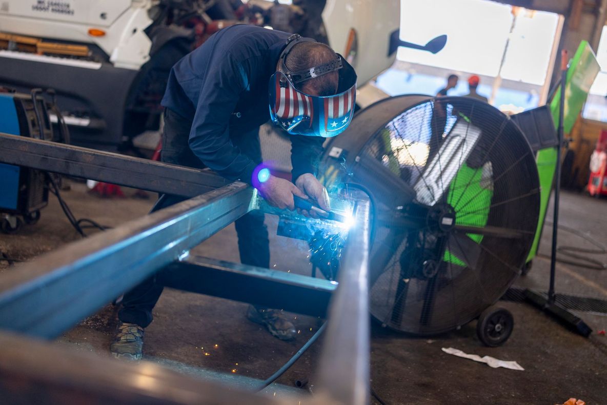 Welder in a workshop, working on a metal frame Welder in a workshop, working on a metal frame
