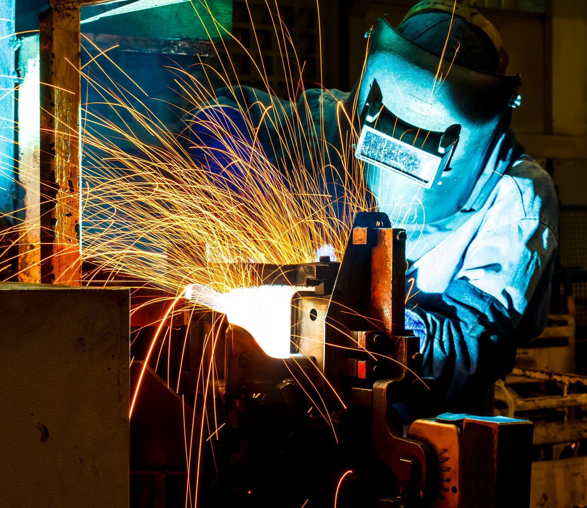 Welder in protective gear, sparks flying, working on metal machinery Welder in protective gear, sparks flying, working on metal machinery