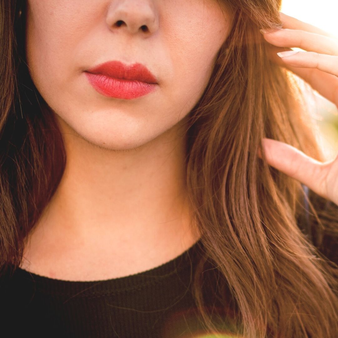 Woman with red lipstick on lips, suggesting suble enhancement