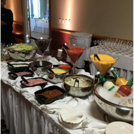 Buffet table with salads, sauces, and fruit bowls set out for a meal indoors