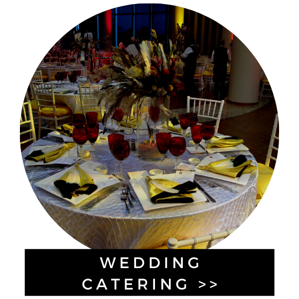 Wedding catering display with a decorated table, wine glasses, and centerpieces at a formal event