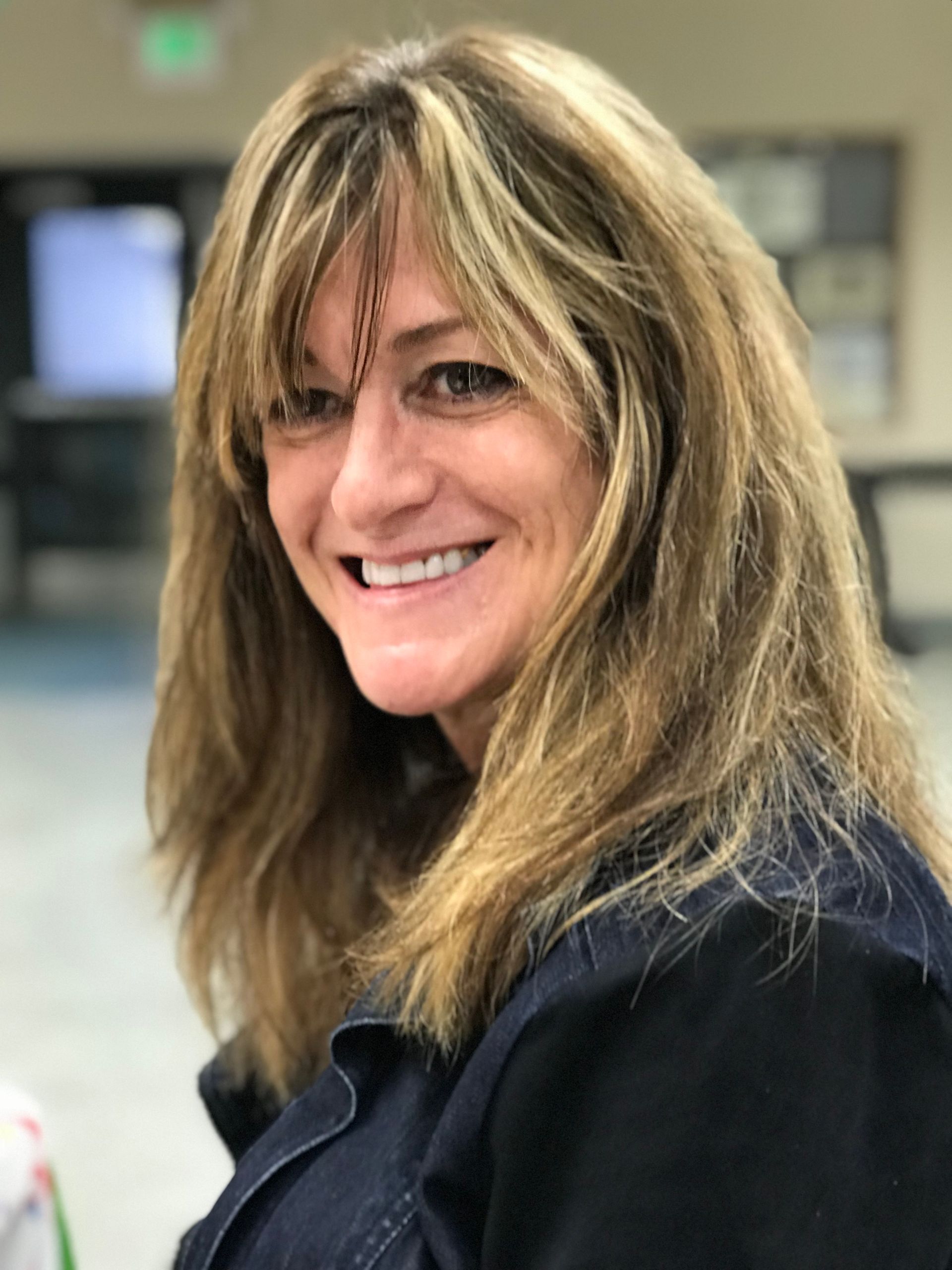 A woman with long blonde hair is smiling for the camera.