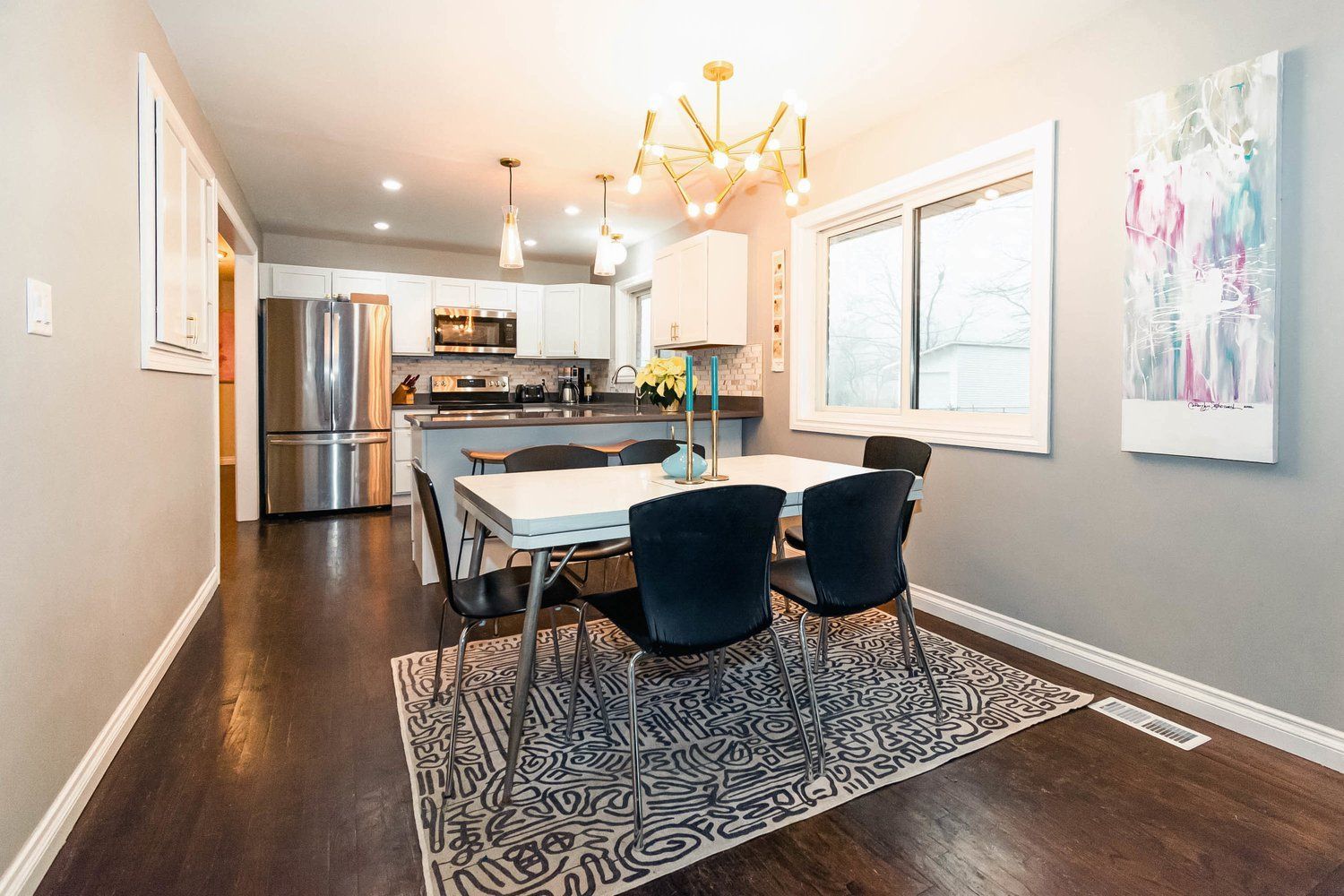 A living room with a couch , chair , rug and television.