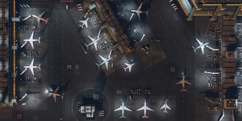 Cargo being loaded onto a large airplane on an airport tarmac on a sunny day.
