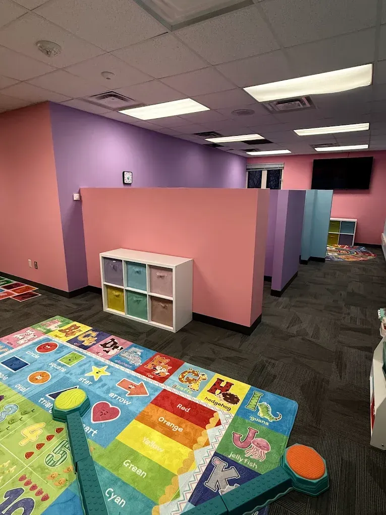 Playroom with colorful walls, carpet, toys, and cubby storage.