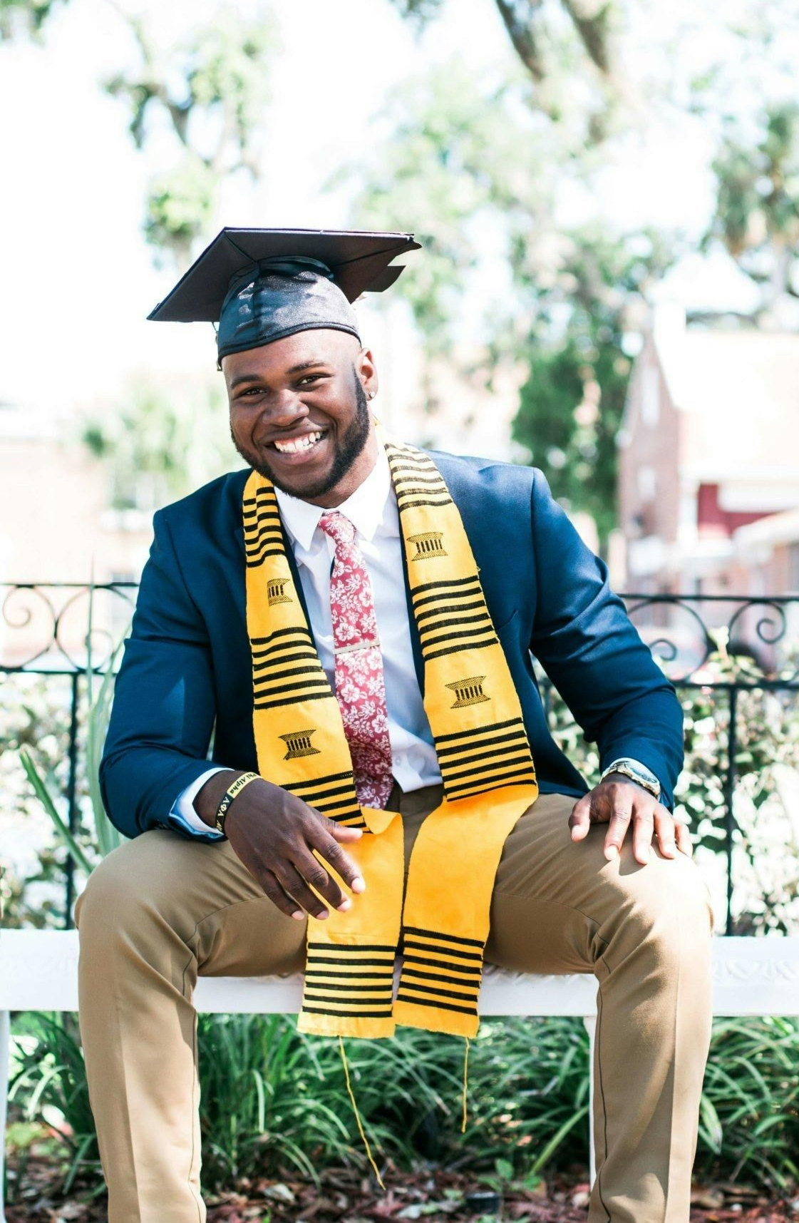A man and a woman are sitting at a table looking at a laptop computer.