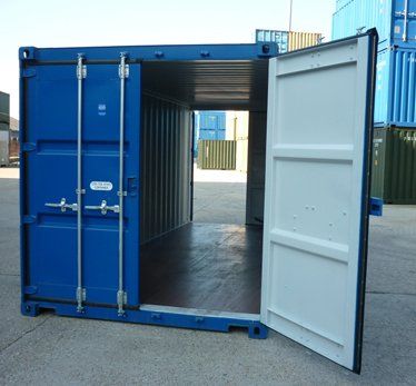 Double door blue shipping container with both doors open in a yard.