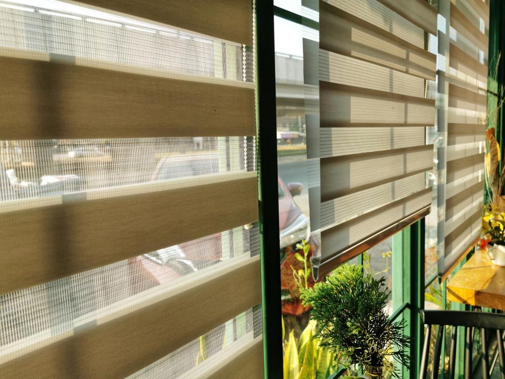 Roller Blinds Or Curtains At The Glass Window — Quality Window Coverings in Mollymook, NSW