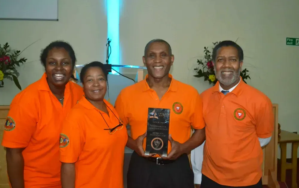 A group of people wearing orange shirts are posing for a picture
