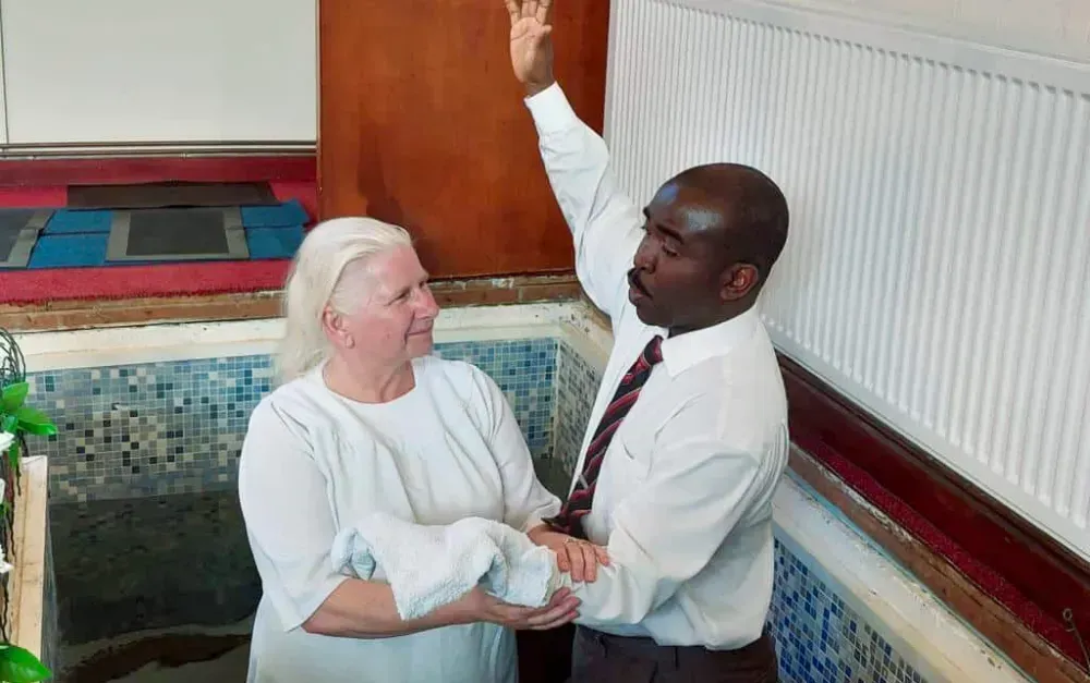 A man and a woman are standing next to each other holding hands.