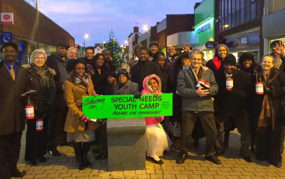 A group of people holding a sign that says special needs youth camp