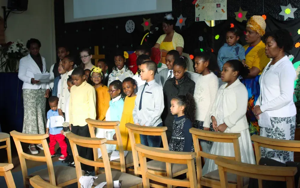 A group of children are singing in a church