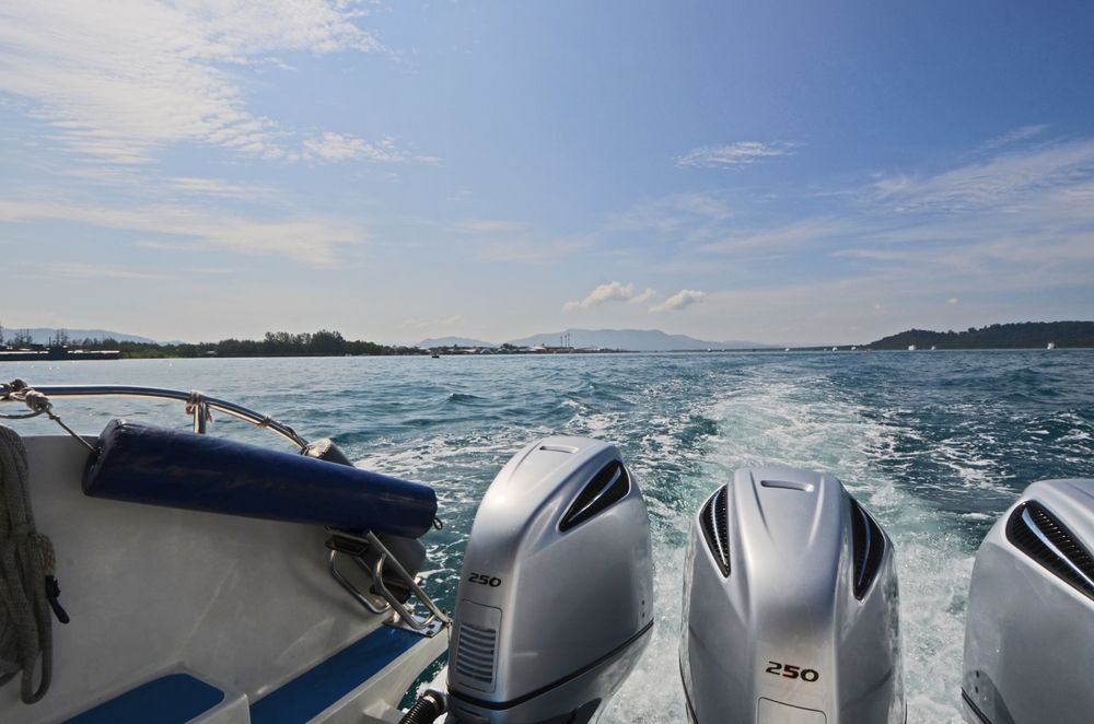 Boat With Three Outboard Motors Speeding on Blue Water — Direct Current Solutions in Mareeba, QLD