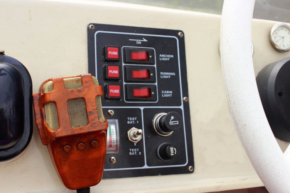 Dashboard with Switches and Lights on A Boat, with A Microphone and Steering Wheel in View — Direct Current Solutions in Mareeba, QLD