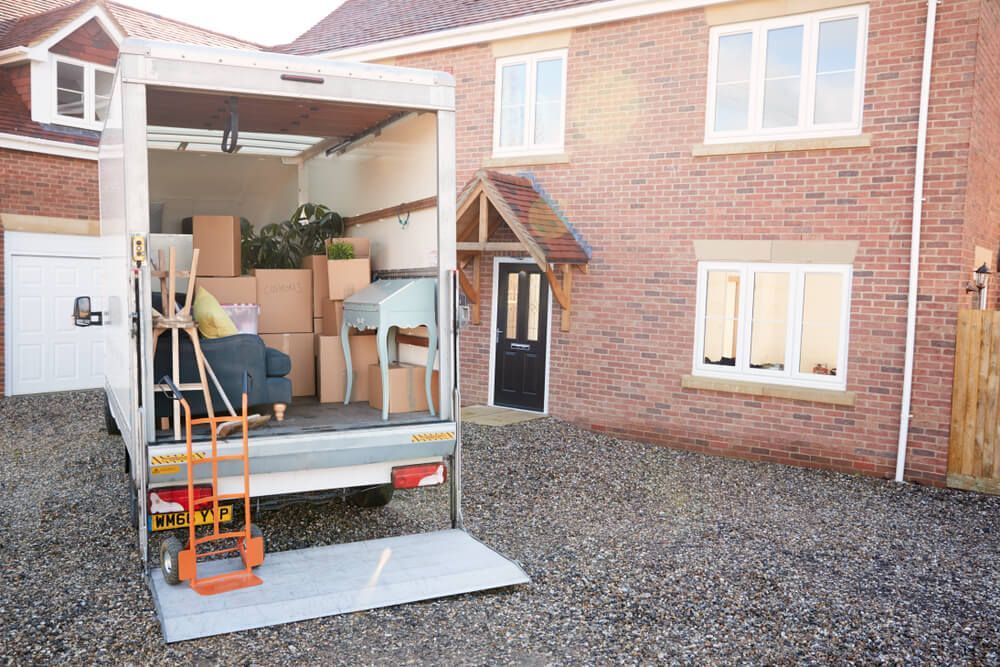 A Moving Truck Is Parked In Front Of A Brick House — Uplift Removals in Mackay, QLD